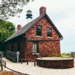 Historic brick lighthouse keeper’s building beside a tropical shoreline