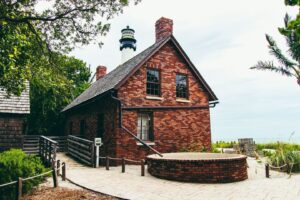 Historic brick lighthouse keeper’s building beside a tropical shoreline